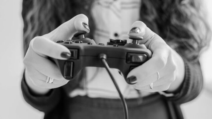 Woman's hands holding PlayStation controller article feature